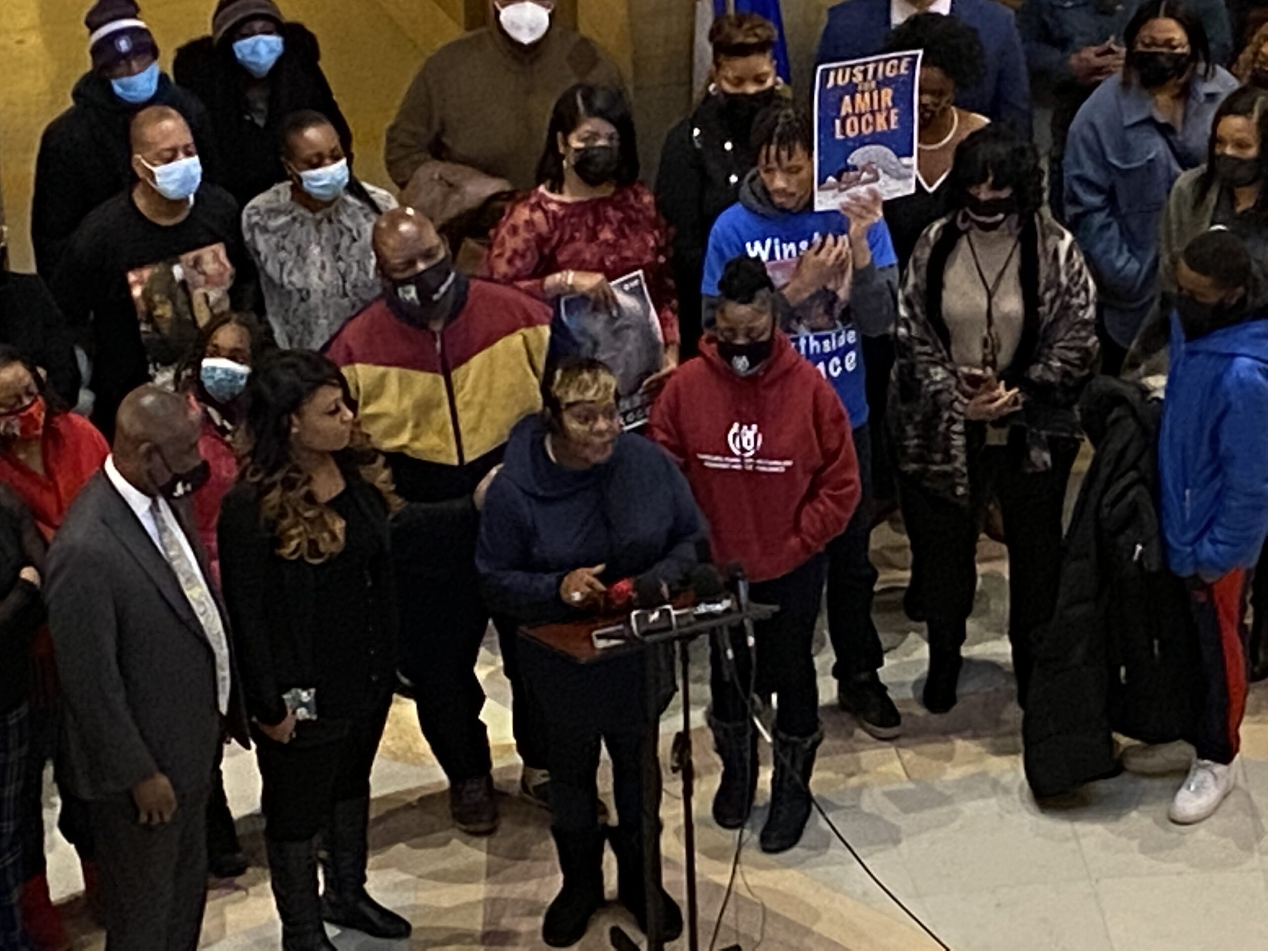 Police department press conference with officers addressing a crowd