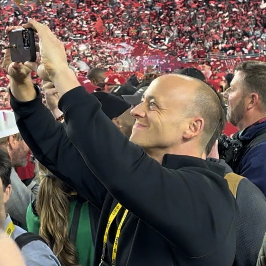 Newly-wed couple celebrating on a football field with confetti in the air