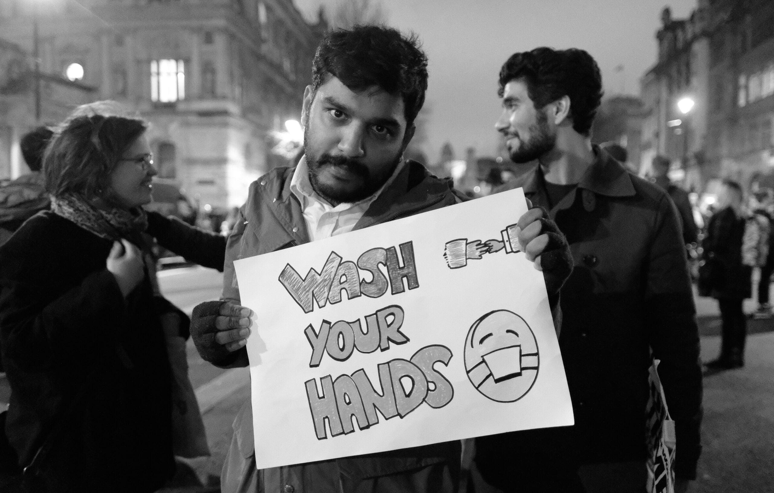 Protesters holding signs advocating for immigrant rights in an urban setting