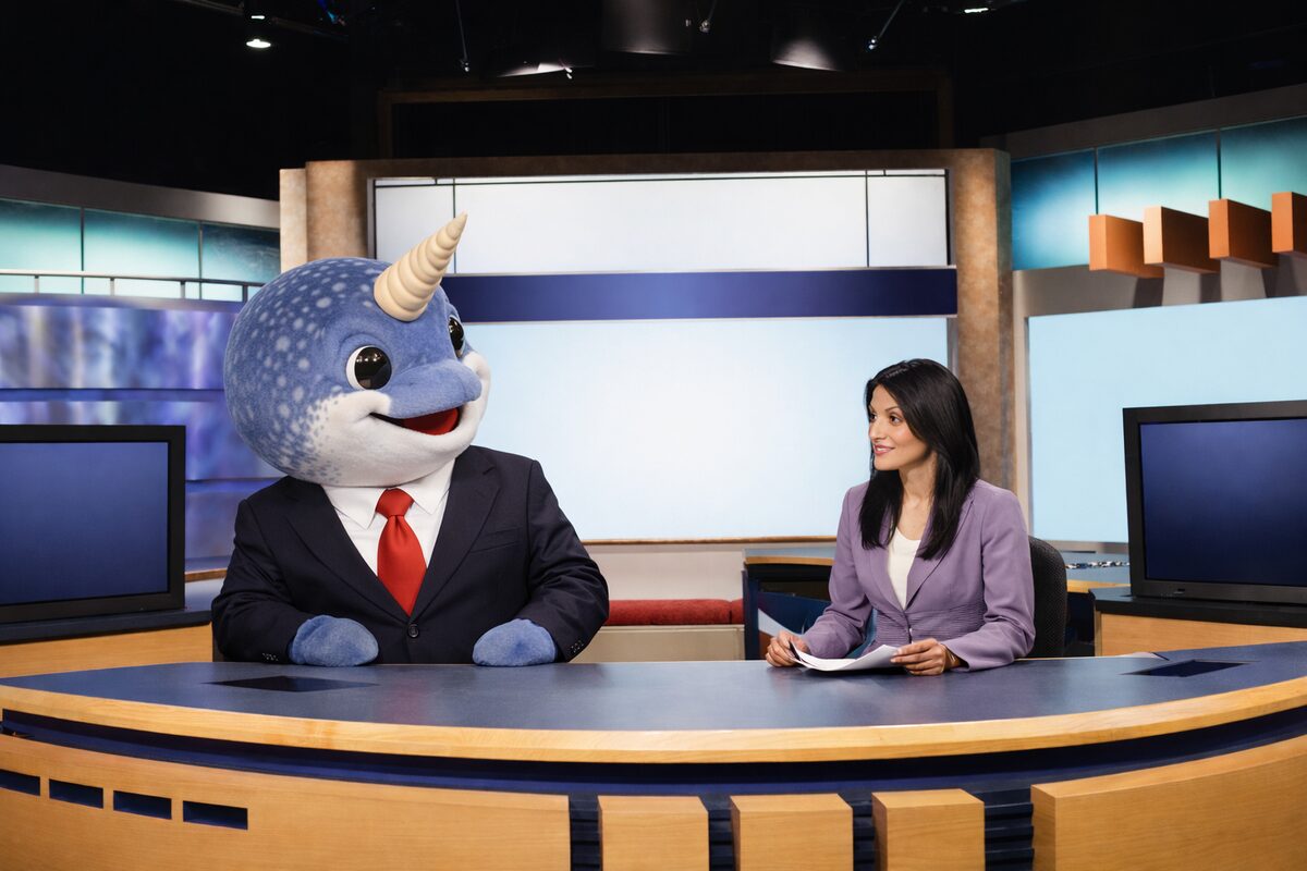 Narwhal Cronkite co-anchoring with a human colleague