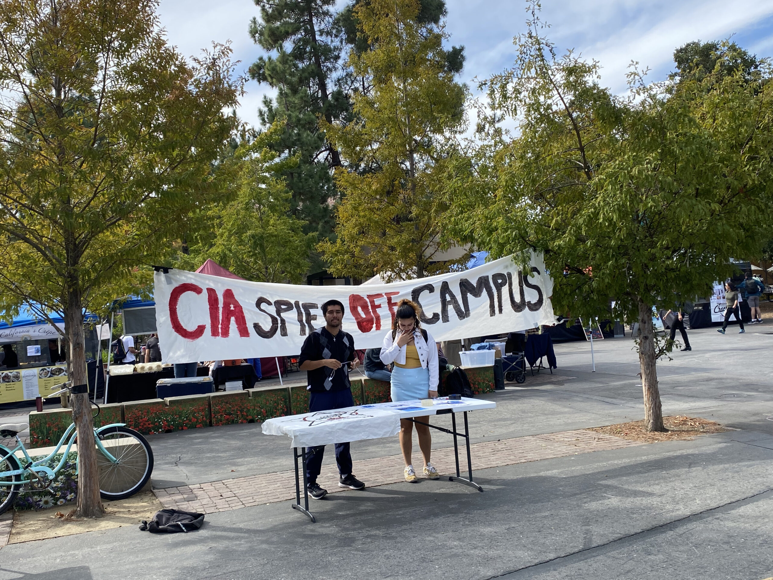 Students walking across a university campus with banners advertising an event