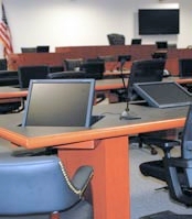 A female government official flanked by two staff members, walking into a government hearing room