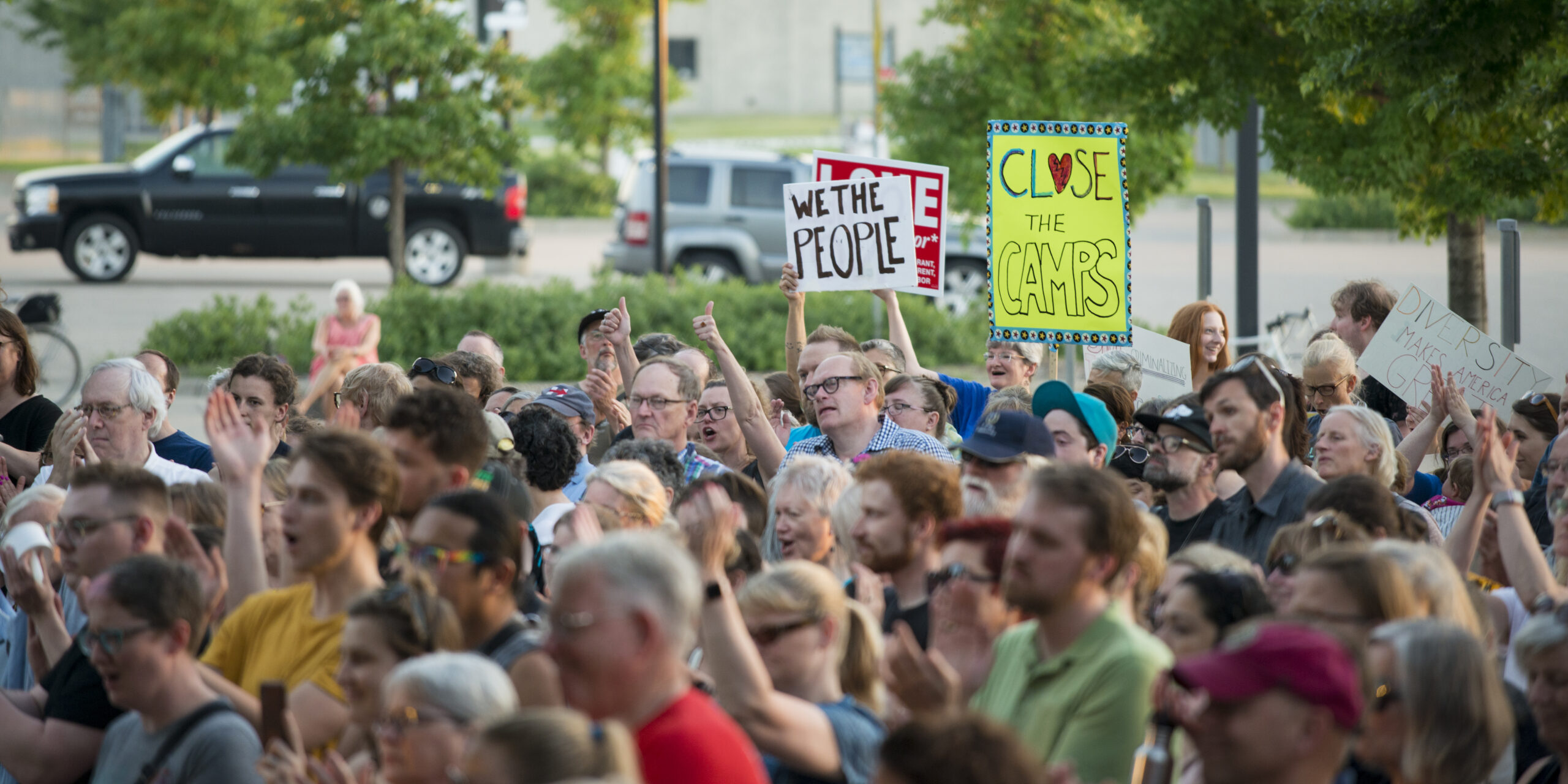 A protest with people holding signs reading