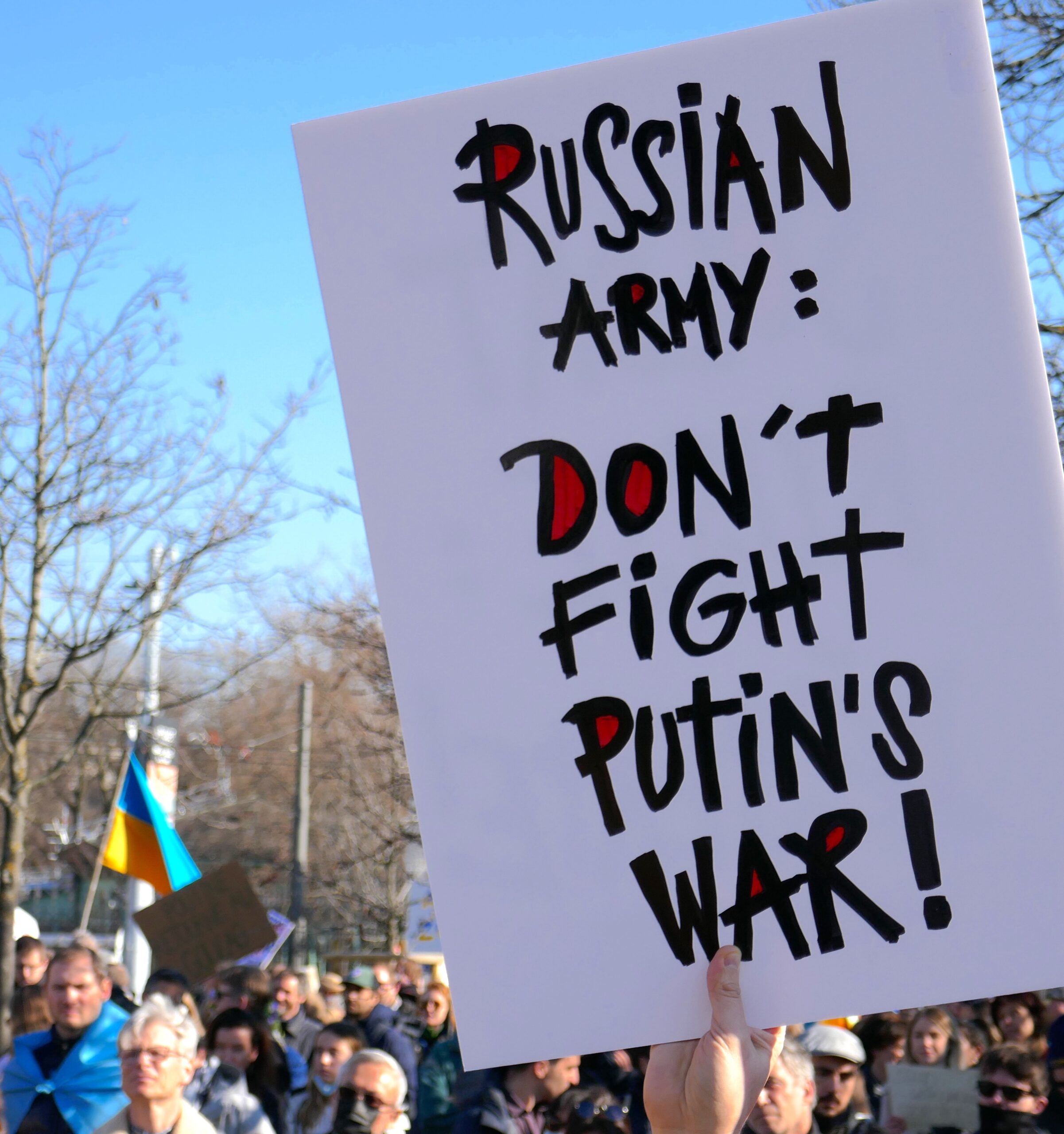 Protestors with banners and flags standing in solidarity in a public square