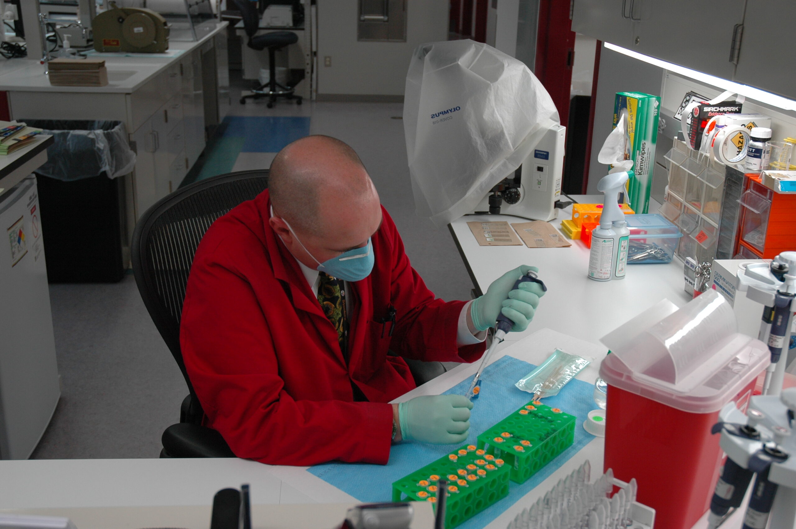 A forensic investigator examining evidence under dim light in a lab setting