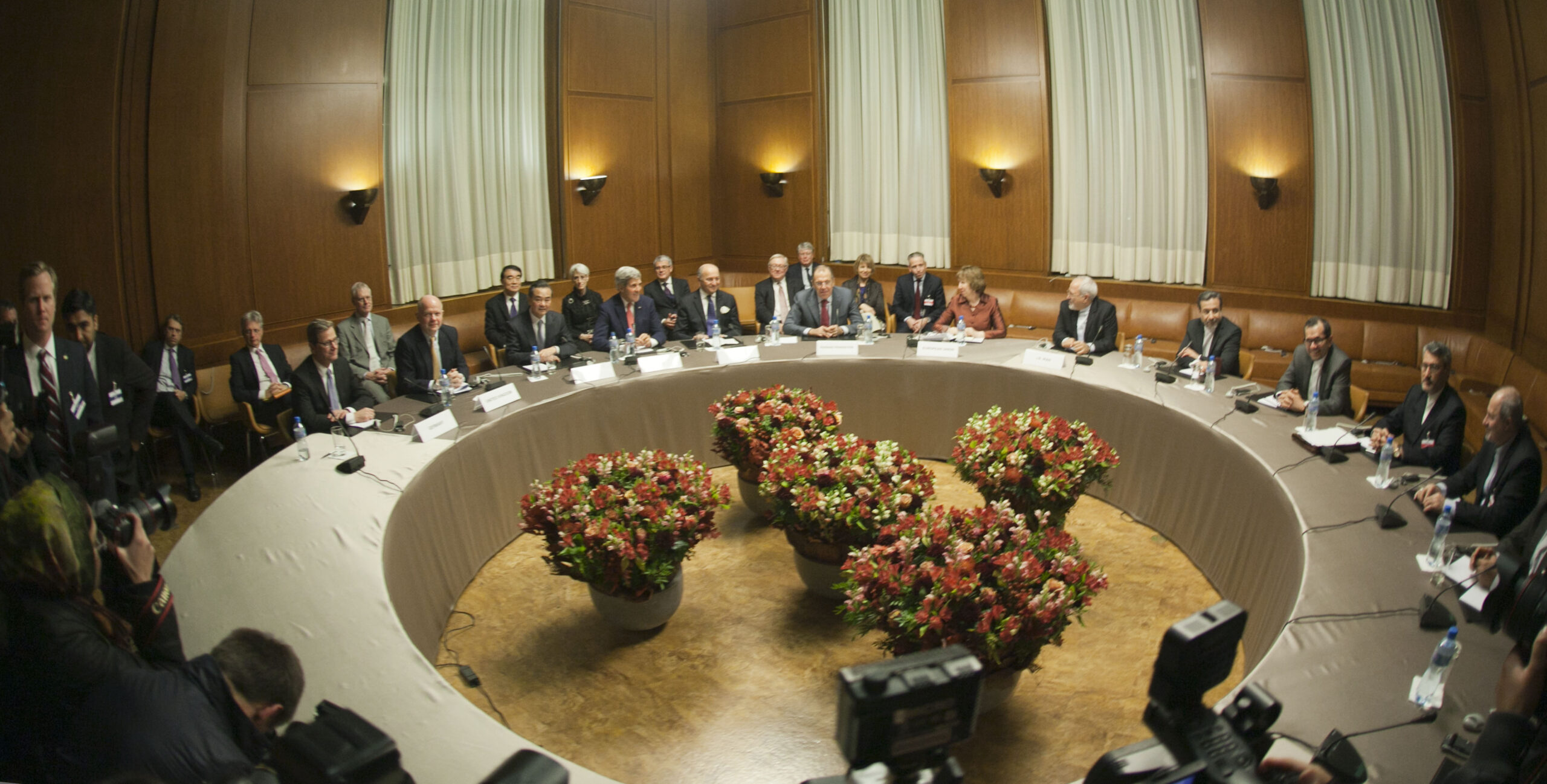 A diplomatic meeting table with Russian and American officials seated