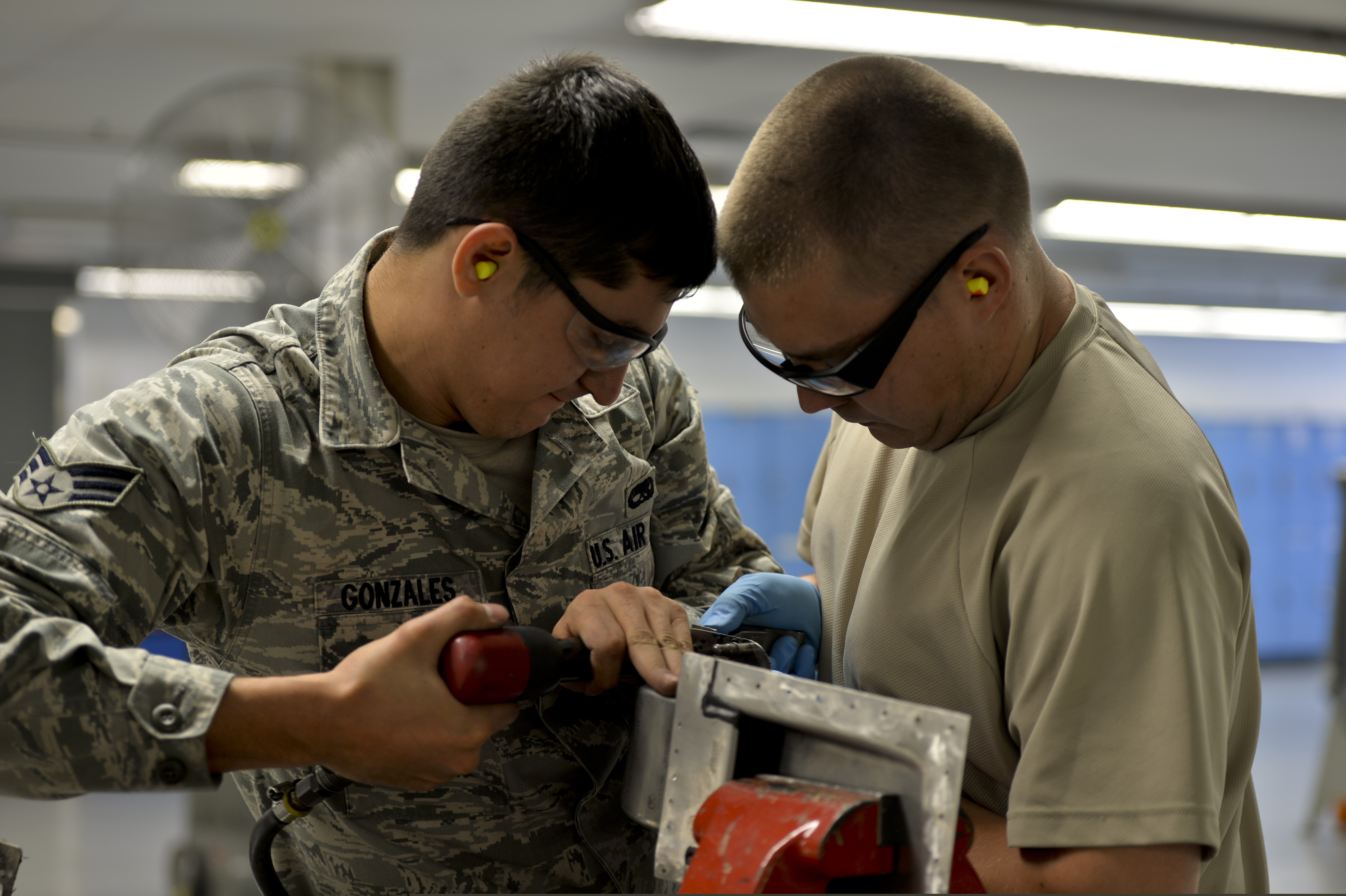 Technicians working on an air-defense battery, showing high-tech military hardware under maintenance